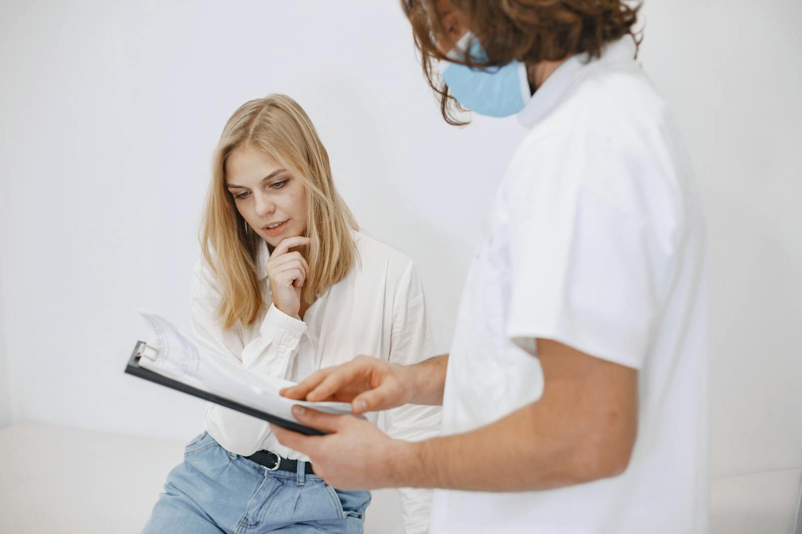 Médica revisando o resultado de um exame em uma prancheta junto a uma paciente durante consulta em um consultório claro e acolhedor