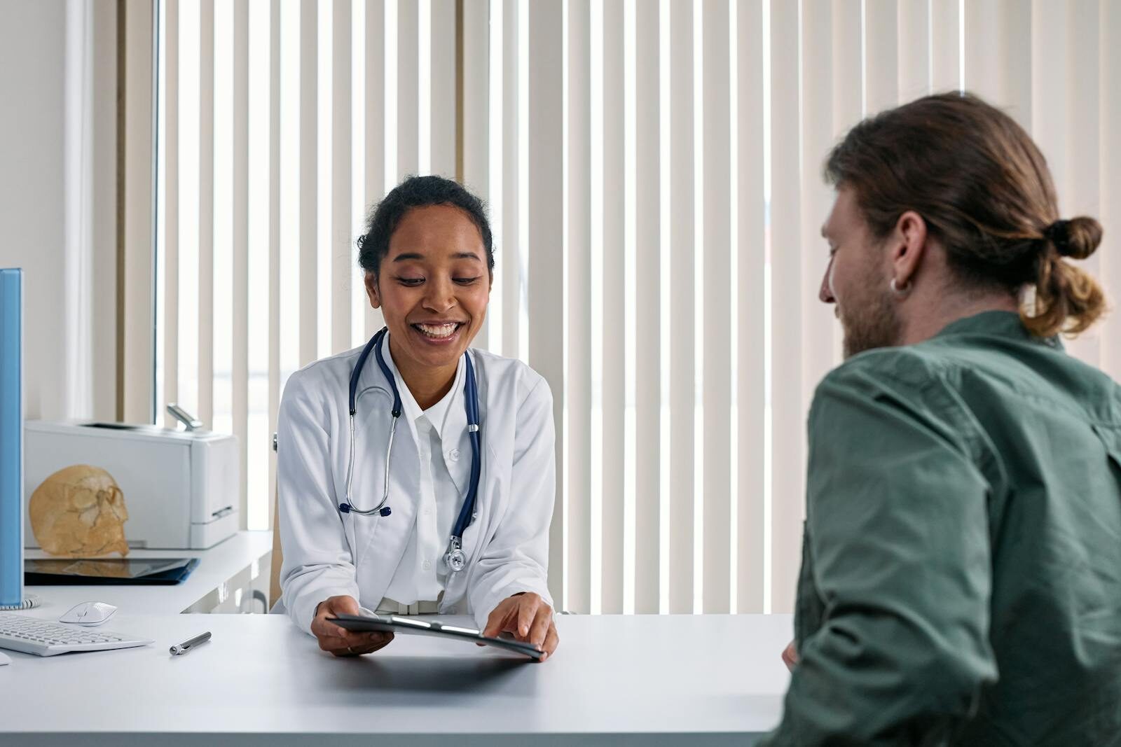 Médica conversando de forma acolhedora com uma paciente durante uma consulta ginecológica em um consultório bem iluminado, orientando sobre métodos contraceptivos como o DIU.