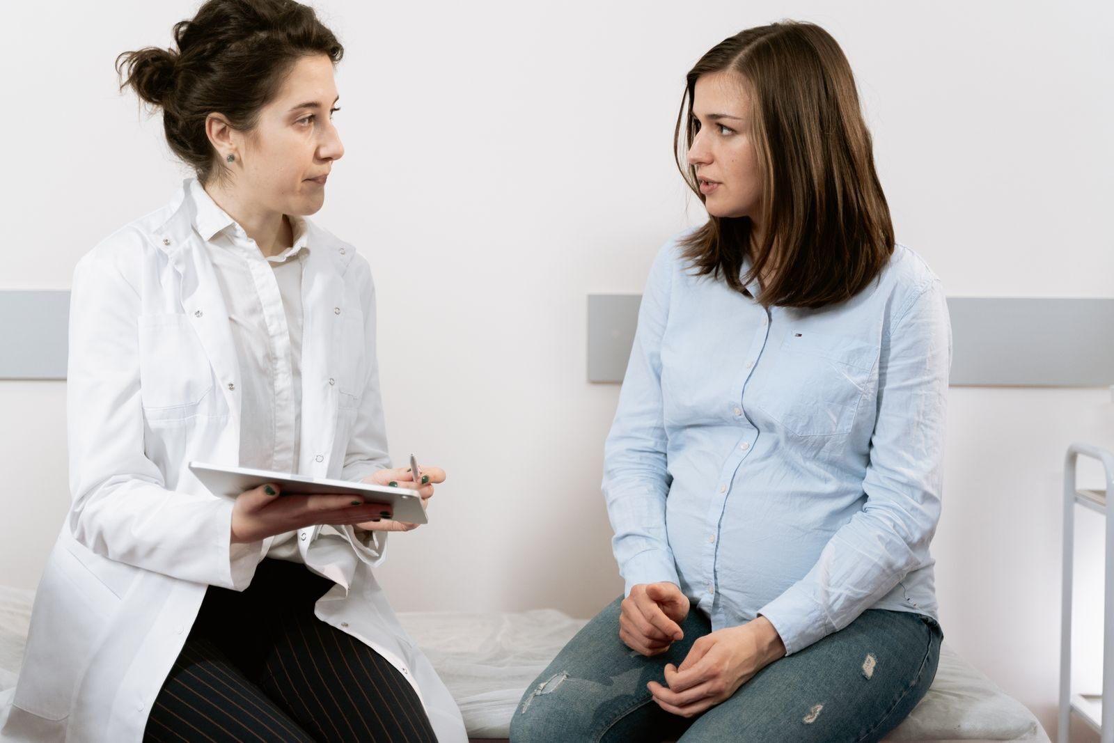 Mulher gestante em consulta com uma médica ginecologista em um consultório claro e acolhedor
