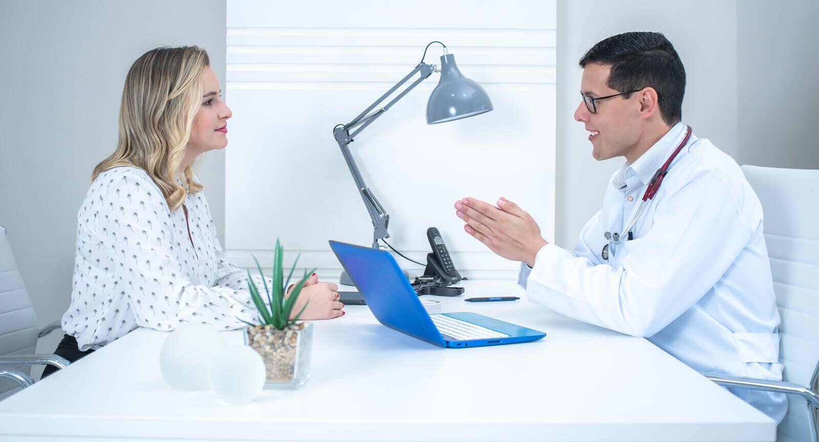 Mulher conversando com um medico durante uma consulta em um consultorio claro e moderno, ambiente acolhedor de cuidado a saude da mulher