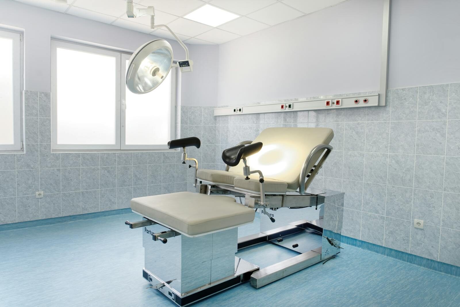 Sala de exame ginecológico moderna e iluminada, com maca de exame e foco cirúrgico, ambiente clínico onde é feita a inserção do DIU