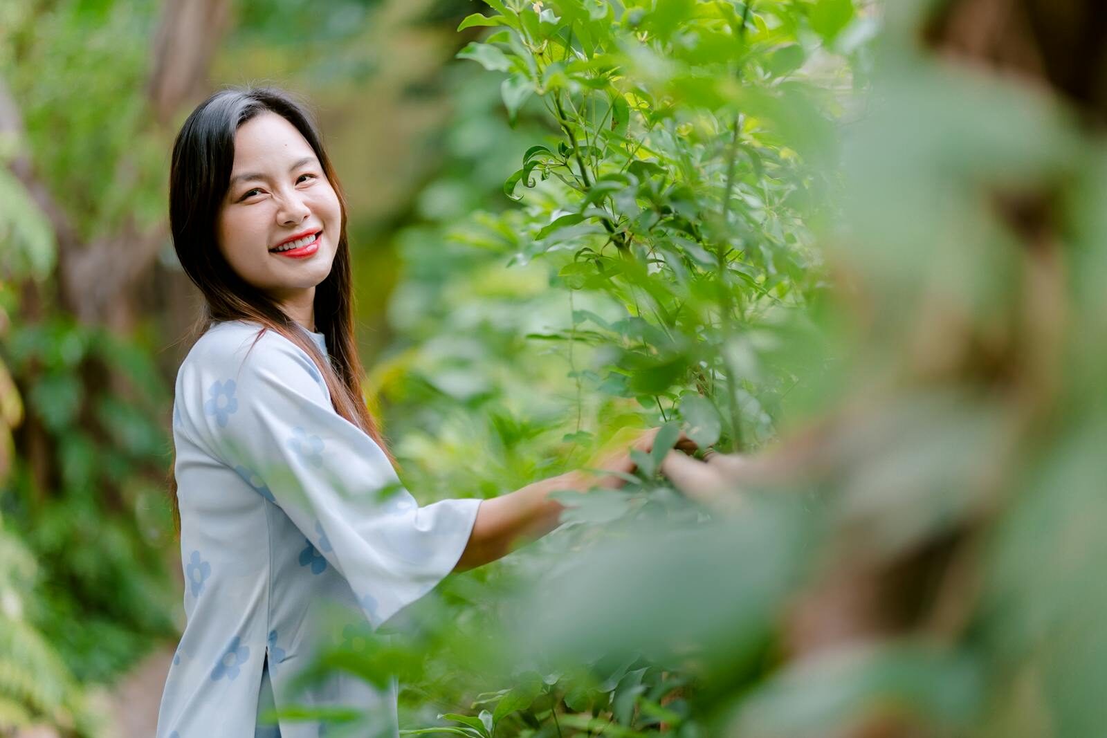 Mulher jovem e saudável sorrindo ao ar livre em meio à vegetação, transmitindo bem-estar e autocuidado